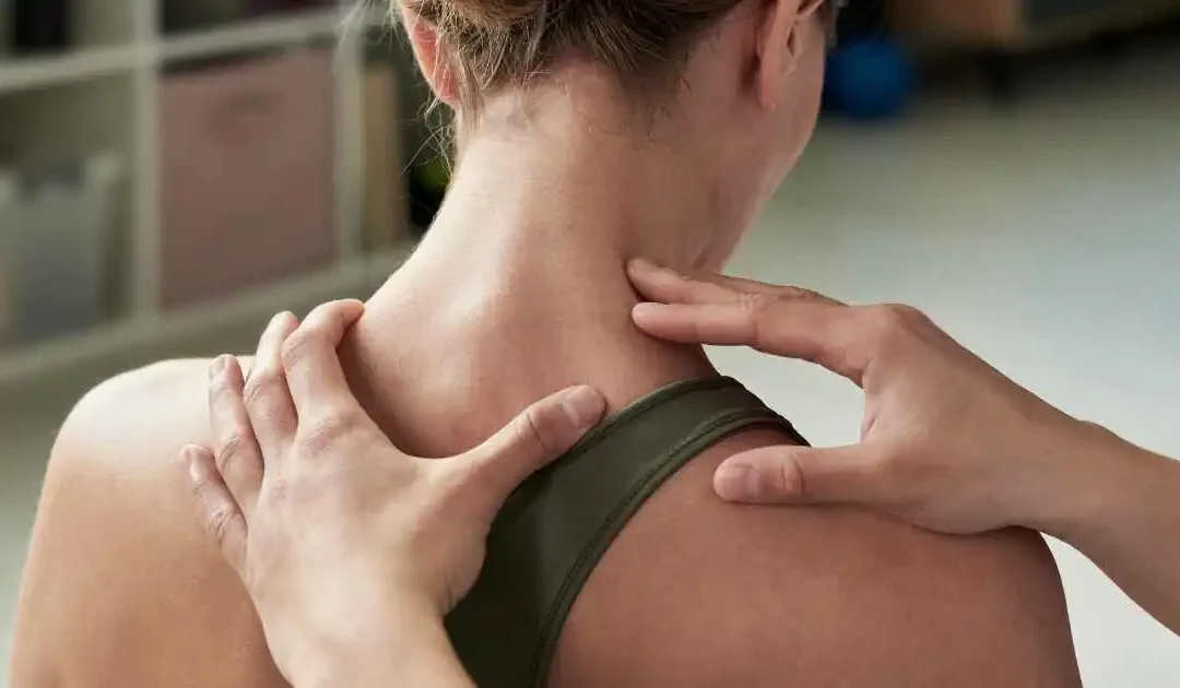 Doctor examining neck and upper spine to evaluate back pain after a car accident