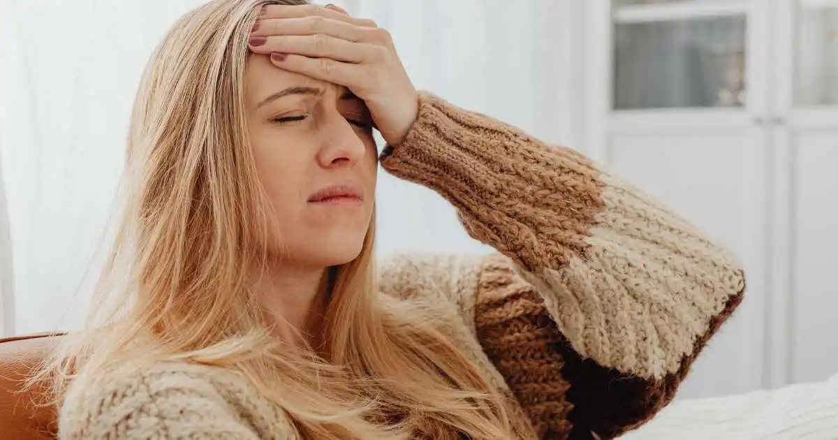 Woman experiencing head pain while distinguishing migraine versus tension headache symptoms