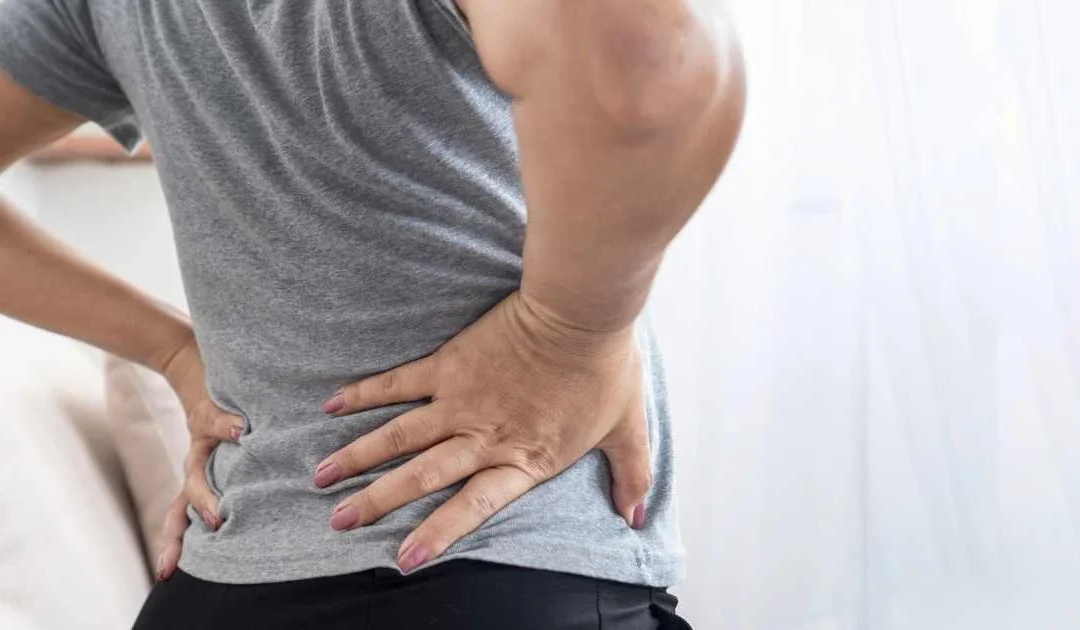 Woman experiencing back pain related to sciatica or pinched nerve symptoms