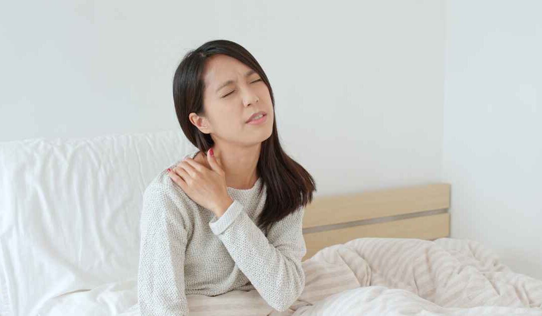 Patient holding shoulder in bed due to nighttime shoulder pain and sleep disruption