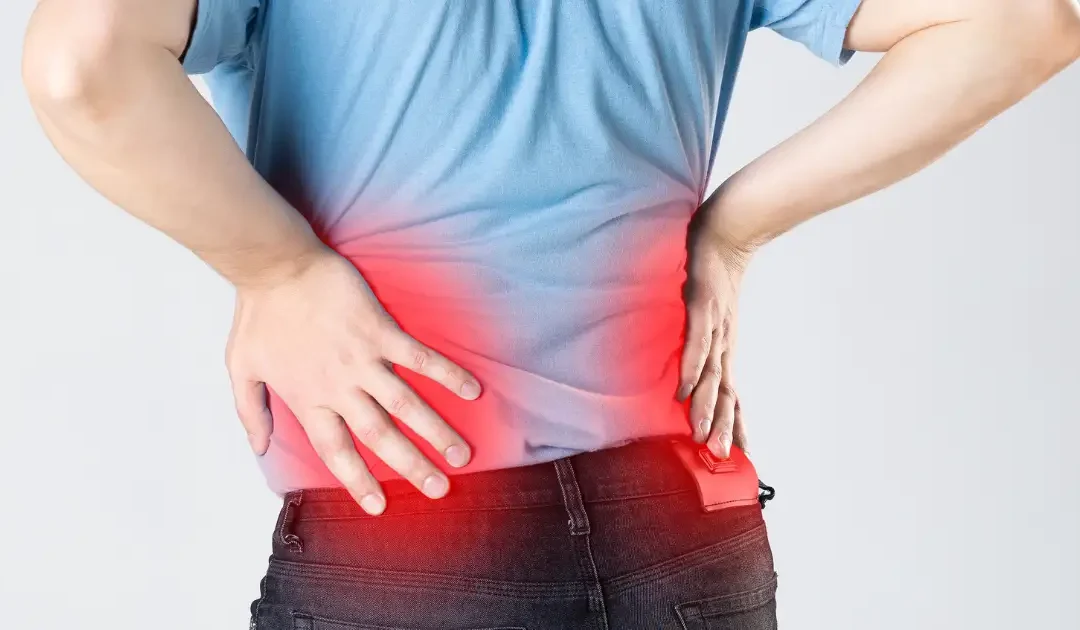 person holding lower back and leg experiencing sciatic nerve pain