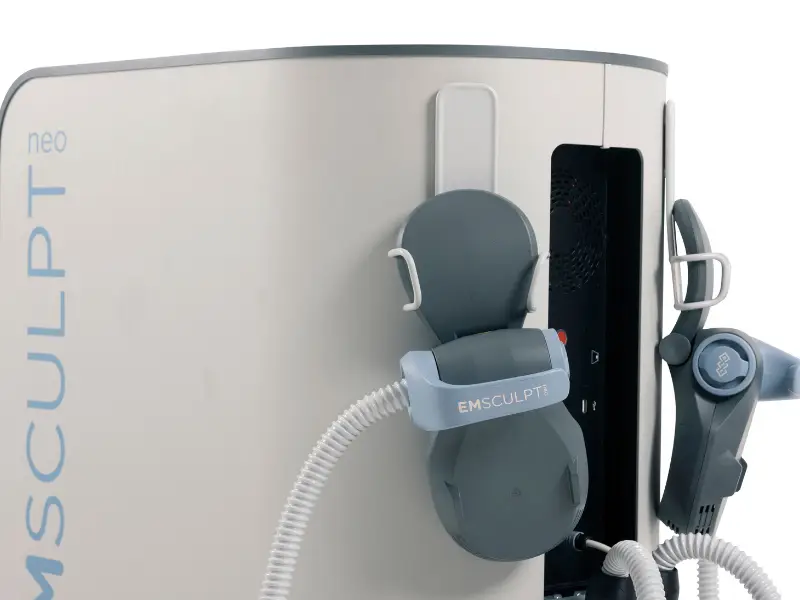 Emsculpt machine - Premier Pain Management Close-up of an EMSculpt Neo body-sculpting device with a grey applicator pad and coiled cable attached to the machine.